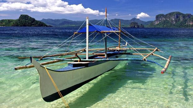 A traditional boat floats on the clear turquoise water near the islands in Palawan, HD Desktop Wallpaper