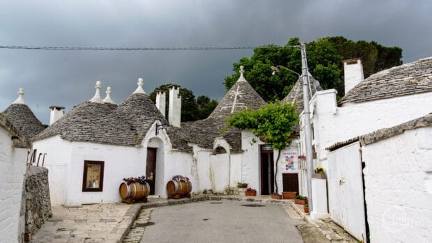 The ancient trulli houses with conical roofs in Alberobello under a cloudy sky, HD Desktop Wallpaper