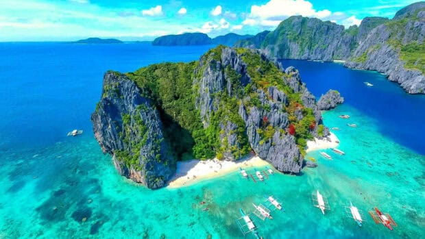 A stunning tropical island with clear turquoise waters and boats in Palawan, HD Desktop Wallpaper