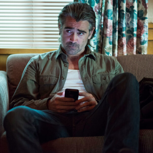 A man from True Detective TV series is sitting on a couch holding a phone and looking thoughtful, HD Desktop Wallpaper