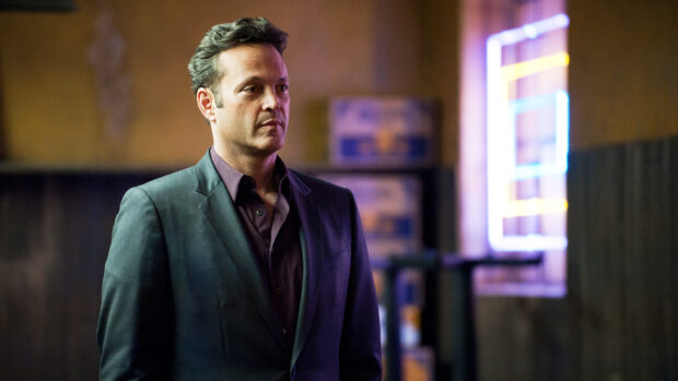 A man in a suit stands thoughtfully inside a dimly lit room with neon lights in the background, HD Desktop Wallpaper