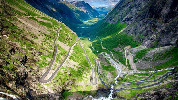 A winding mountain road surrounded by lush greenery and cliffs in Norway, 4K Desktop Wallpaper