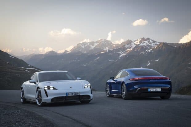 The Porsche Taycan cars are shown on a mountain road with snowy peaks in the background, HD Desktop Wallpaper