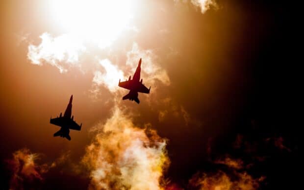 Two jet fighters are flying in formation with a dramatic sunset sky in the background, 2K Desktop Wallpaper