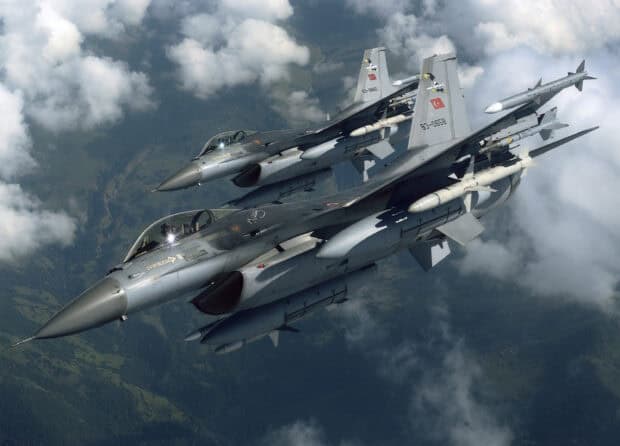 Two jet fighters are flying above the clouds and mountainous terrain, 2K Desktop Wallpaper