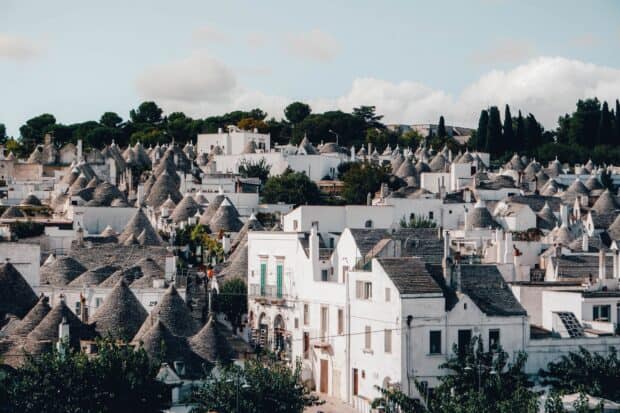 The Alberobello Wallpapers show unique trulli houses with cone shaped roofs in a sunny setting, 2K Desktop Wallpaper