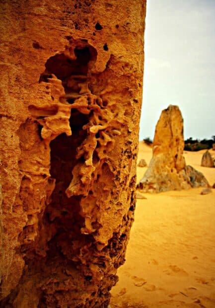 The image shows intricate rock formations at Nambung National Park with sandy desert surroundings, HD Mobile Wallpaper