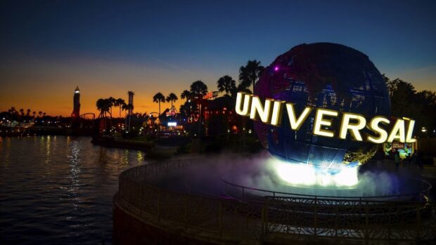 Orlando Wallpapers show the famous Universal globe glowing at sunset with palm trees and water around, HD Desktop Wallpaper