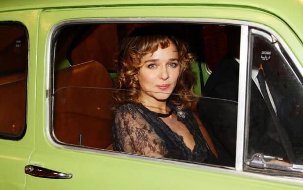 Valeria Golino wallpapers shows a woman sitting in a green vintage car looking out the window, 2K Desktop Wallpaper