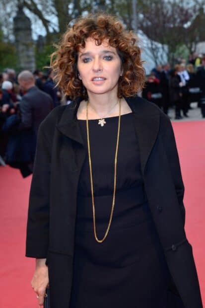 Valeria Golino wears a black outfit with gold accessories at a public event, HD Desktop Wallpaper
