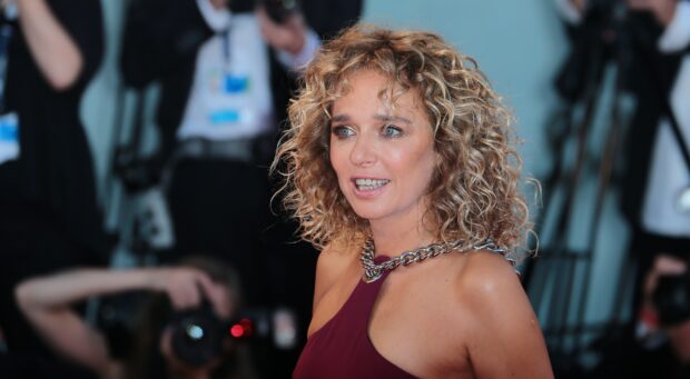 Valeria Golino is wearing a burgundy dress and silver necklace at an event, HD Desktop Wallpaper