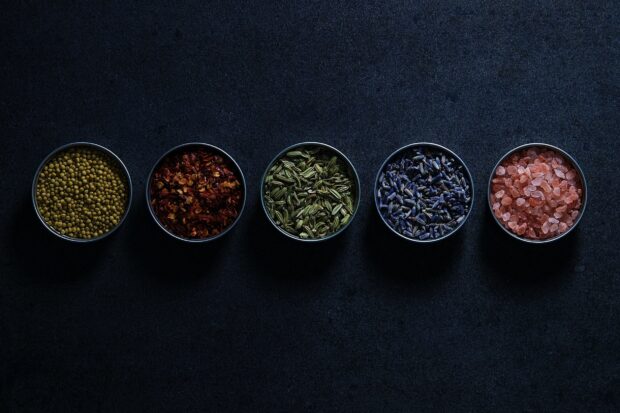 A variety of seasoning is arranged in metal bowls on a dark surface, HD Desktop Wallpaper