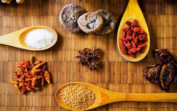 A collection of seasoning spices arranged on a wooden surface with star anise and dried chili, HD Desktop Wallpaper