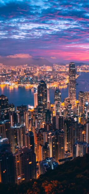 The Hong Kong skyline shows illuminated skyscrapers under a colorful sunset sky, HD Phone Wallpaper
