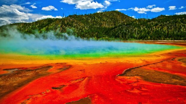 The vibrant Yellowstone National Park hot spring shows colorful geothermal activity under a partly cloudy sky, HD Desktop Wallpaper