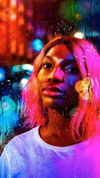A colorful close up of Michaela Coel with glowing city lights and raindrops on glass, HD Phone Wallpaper