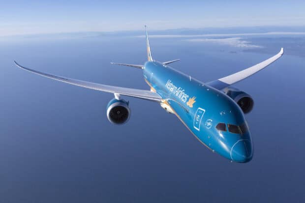 A Vietnam Airlines aircraft is flying above the sea with clear skies in the background, HD Desktop Wallpaper
