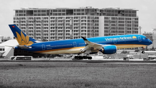 A Vietnam Airlines airplane is landing with a city building background, HD Desktop Wallpaper