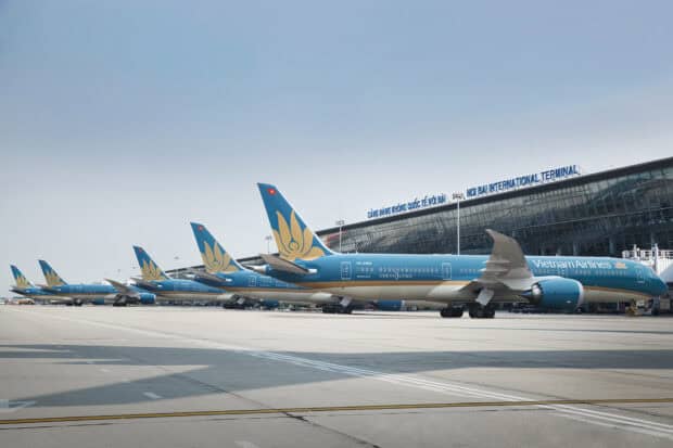 Several Vietnam Airlines airplanes are parked in a row at an international terminal, HD Desktop Wallpaper