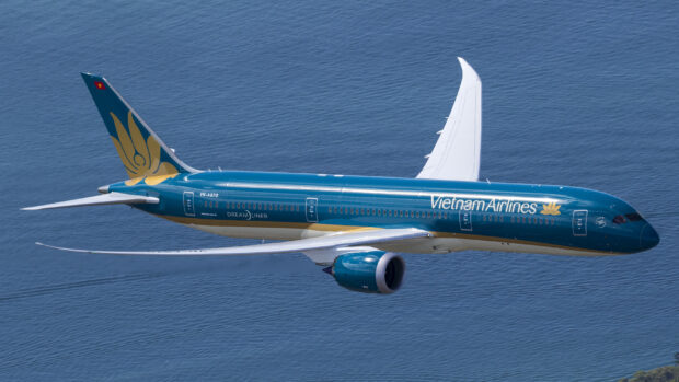 A Vietnam Airlines aircraft flies above the deep blue sea in clear skies, 2K Desktop Wallpaper