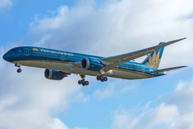 A Vietnam Airlines jet is flying against a blue sky with light clouds, 2K Desktop Wallpaper