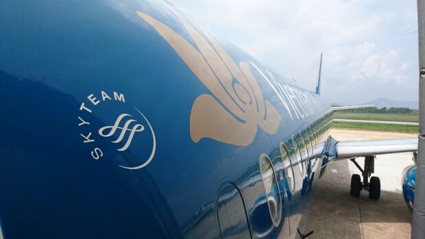 A close up of a Vietnam Airlines jet showing its blue fuselage and logo on a clear day, 4K Desktop Wallpaper