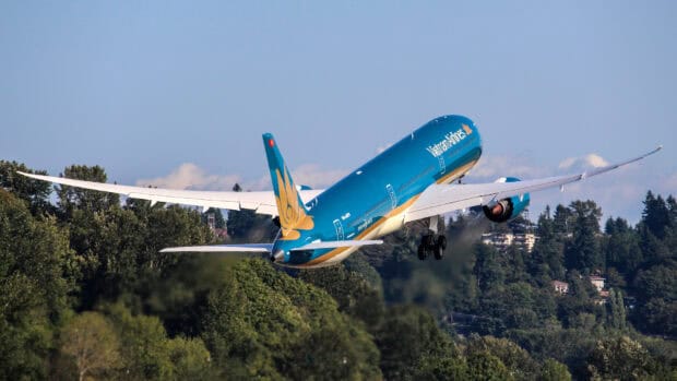 A Vietnam Airlines plane is captured mid flight over a forested area, Vietnam Airlines Wallpapers, HD Desktop Wallpaper