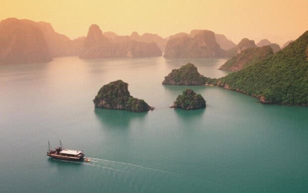 A traditional boat sails near limestone islands in Vietnam wallpapers, HD Desktop Wallpaper