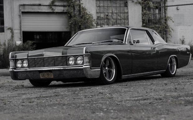 A classic Lincoln car is parked near an old building showing sleek design and polished details, HD Desktop Wallpaper