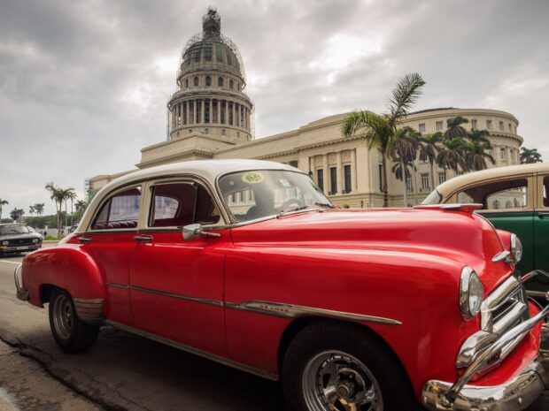 A red vintage car parked near the Capitol building in Havana Cuba with palm trees around, HD Desktop Wallpaper