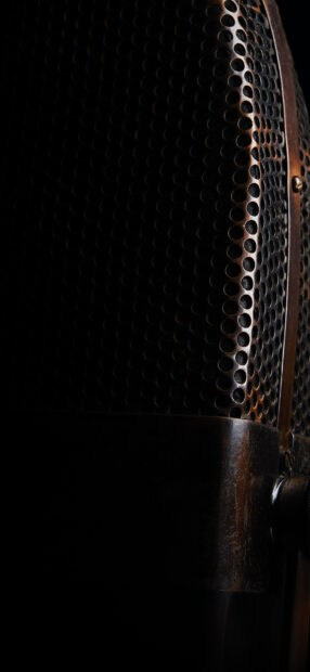 A vintage microphone is shown with a detailed metal grill against a black background, HD Mobile Wallpaper