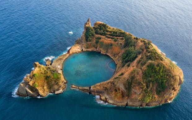 A volcanic island in The Azores features lush vegetation and clear blue waters, HD Desktop Wallpaper