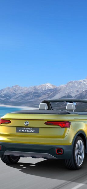 A yellow Volkswagen T Cross Breeze driving with mountains in the background, HD Mobile Wallpaper