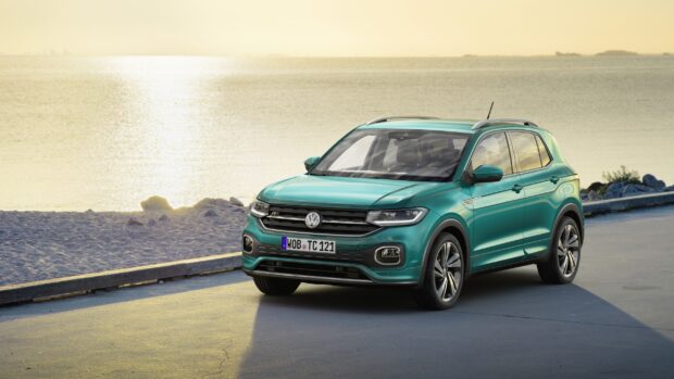 A Volkswagen T Cross parked near the beach with sunset reflecting on its body, 2K Desktop Wallpaper