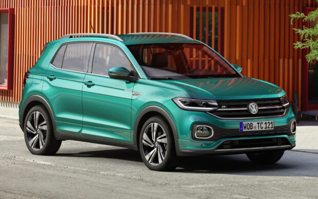 A green Volkswagen T Cross parked near an orange building exterior, HD Desktop Wallpaper