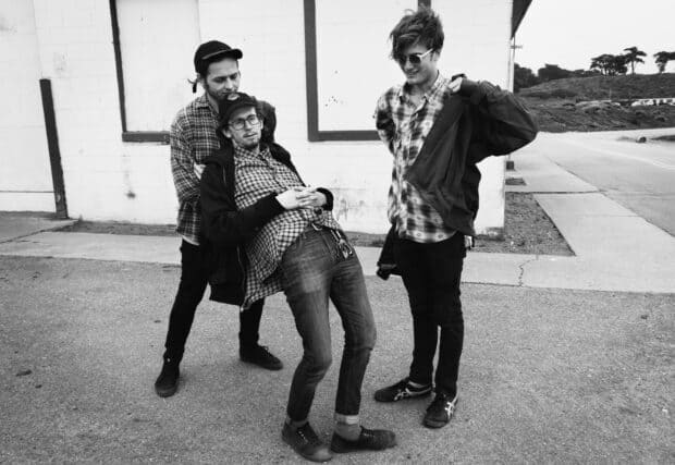 Three men from Vundabar band share a lighthearted moment outdoors, HD Desktop Wallpaper