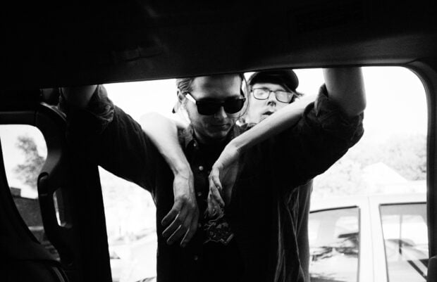 The Vundabar Band members lean casually in a black and white photo outside a vehicle, HD Desktop Wallpaper