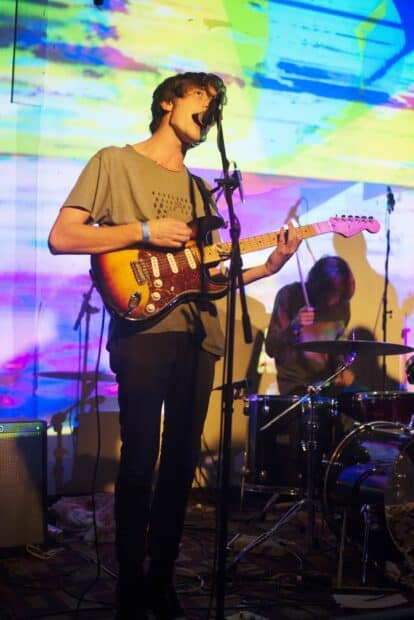 A musician plays guitar and sings during a Vundabar Band performance, HD Desktop Wallpaper