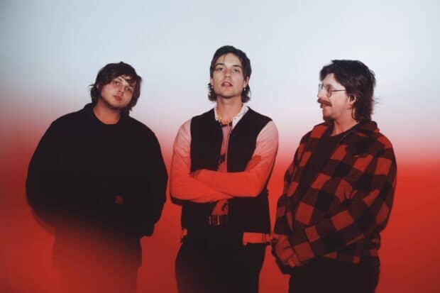 The Vundabar band stands in front of a red and white gradient background looking at the camera, 2K Desktop Wallpaper