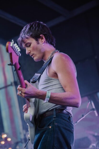 A Vundabar band guitarist is focused on playing his electric guitar during a live performance, HD Mobile Wallpaper