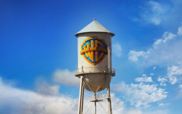 The Warner Bros Studios water tower stands tall against a bright blue sky with scattered clouds, 2K Desktop Wallpaper