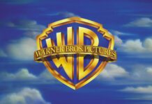 The Warner Bros logo is displayed against a cloudy blue sky with Warner Bros Wallpapers text, 2K Desktop Wallpaper