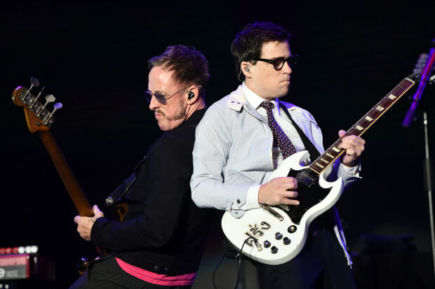 Two Weezer band members performing on stage with guitars, 2K Desktop Wallpaper