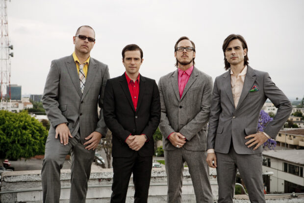 The Weezer band members are posing in suits on a rooftop, HD Desktop Wallpaper