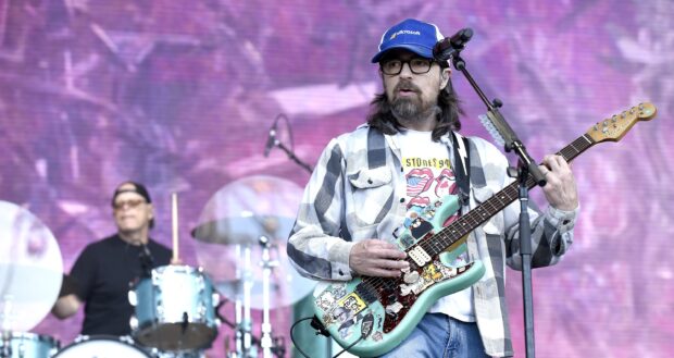 A guitarist from Weezer performing live with stickers on his guitar, 2K Desktop Wallpaper