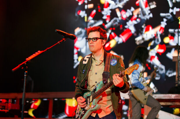 A guitarist from Weezer plays an electric guitar during a live concert, HD Desktop Wallpaper