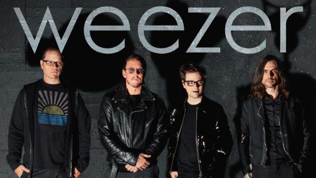 The Weezer band members standing together with a dark wall background, 2K Desktop Wallpaper