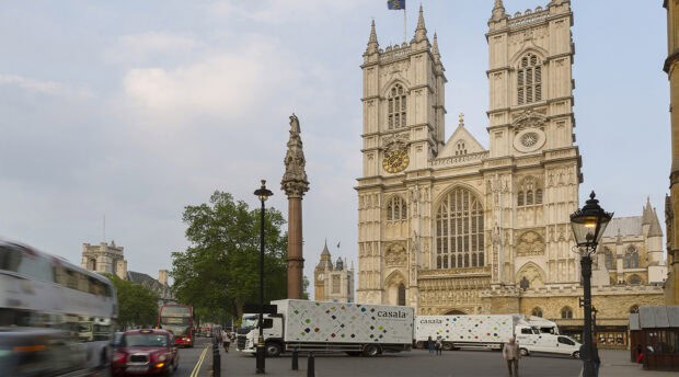 Westminster Abbey stands prominently beside a busy London street filled with vehicles and pedestrians, HD Desktop Wallpaper
