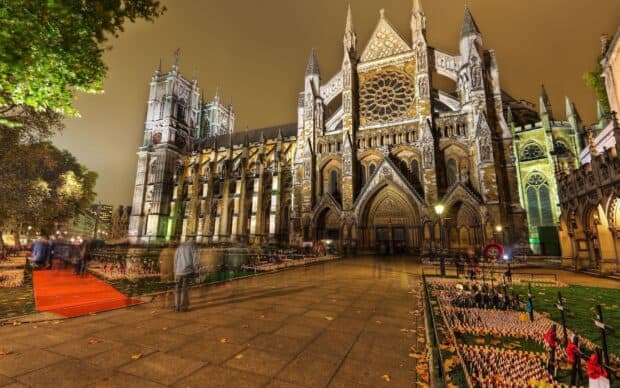 Westminster Abbey wallpapers show the illuminated historic church with people walking nearby, 2K Desktop Wallpaper