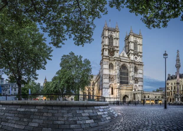 The historic Westminster Abbey stands tall surrounded by trees and open space under a clear sky, HD Desktop Wallpaper